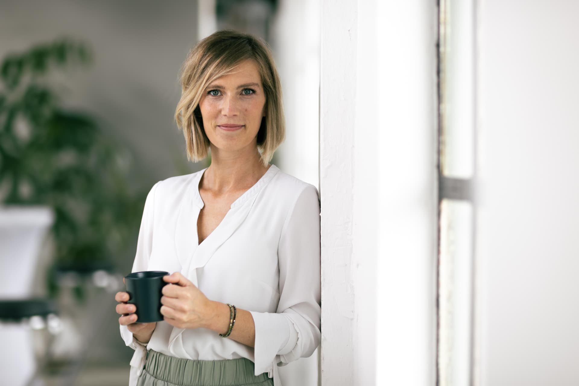 Laura im Gespräch mit einer Tasse Kaffee